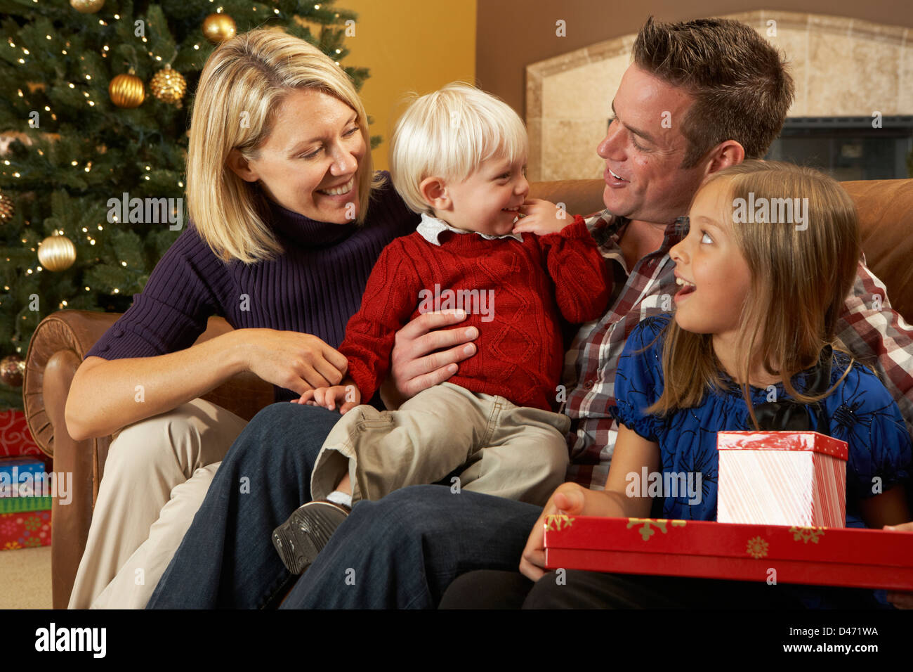 Familie Eröffnung präsentiert vor Weihnachtsbaum Stockfoto