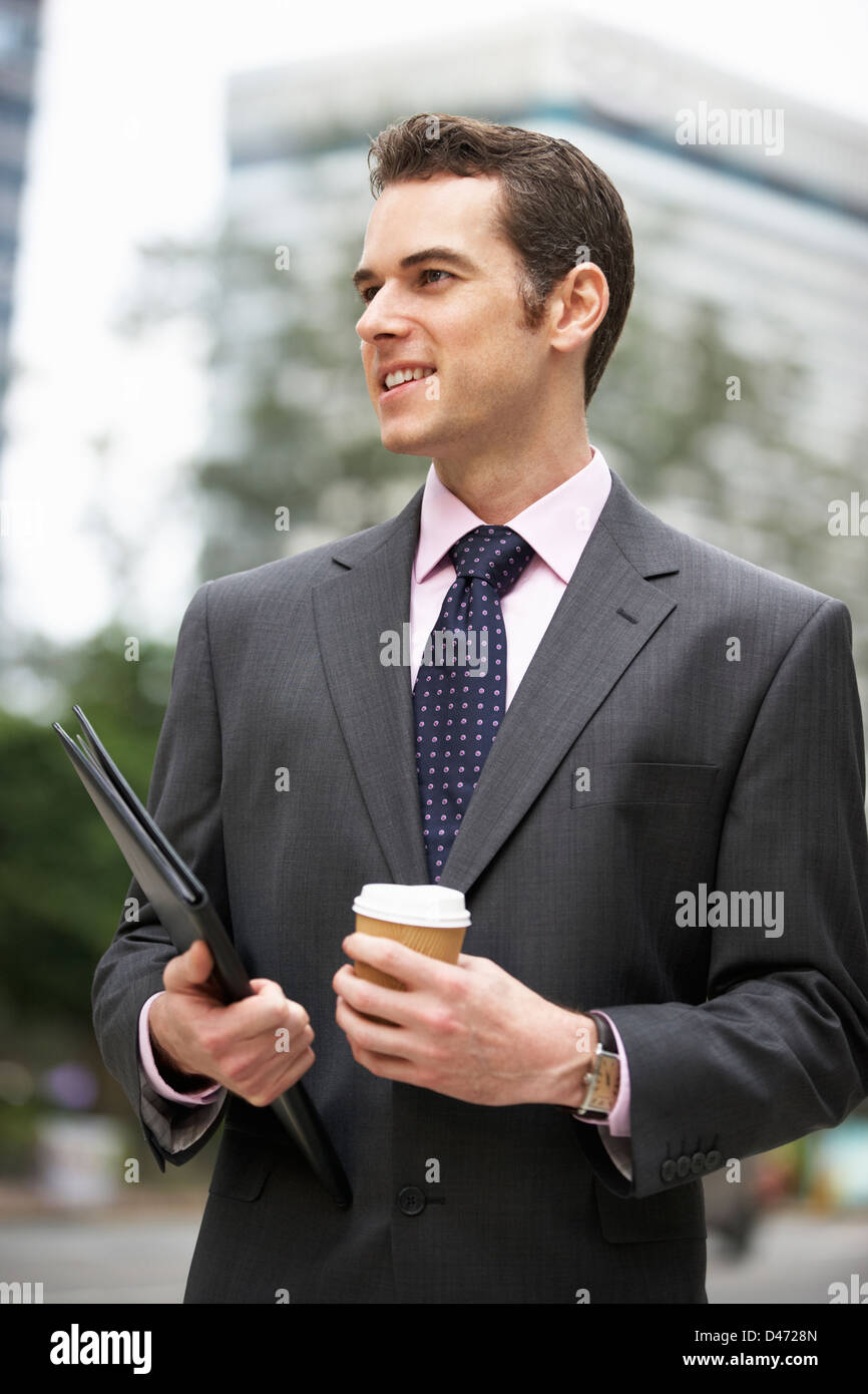 Geschäftsmann zu Fuß entlang der Straße halten Kaffee zum mitnehmen Stockfoto