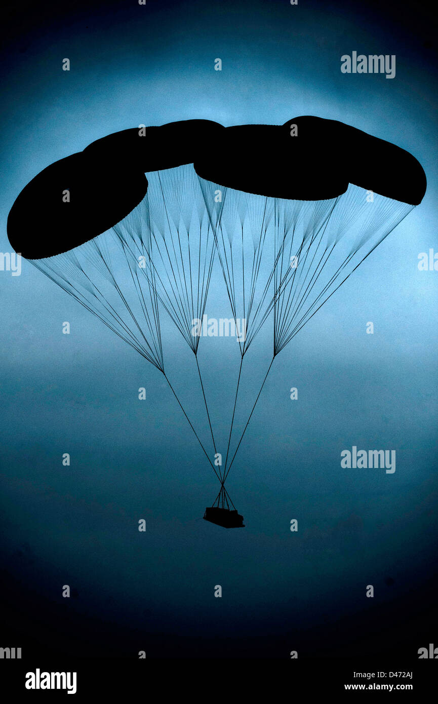 Ein Stück der Ladung steigt im Morgengrauen mit dem Fallschirm nach Fallenlassen durch eine US Luftwaffe c-17 Globemaster während einem 1.700 Fallschirm gemeinsame betriebliche Übung 25. Februar 2013 in Fort Bragg, NC. Stockfoto