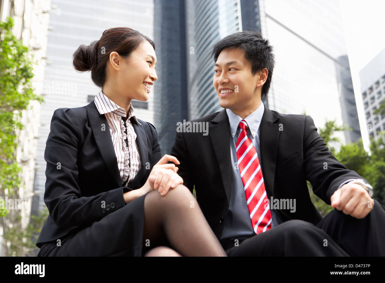 Chinesischer Unternehmer und Unternehmerin sprechen außerhalb Büro Stockfoto Chinesischer Unternehmer und Unternehmerin sprechen außerhalb Büro Stockfoto