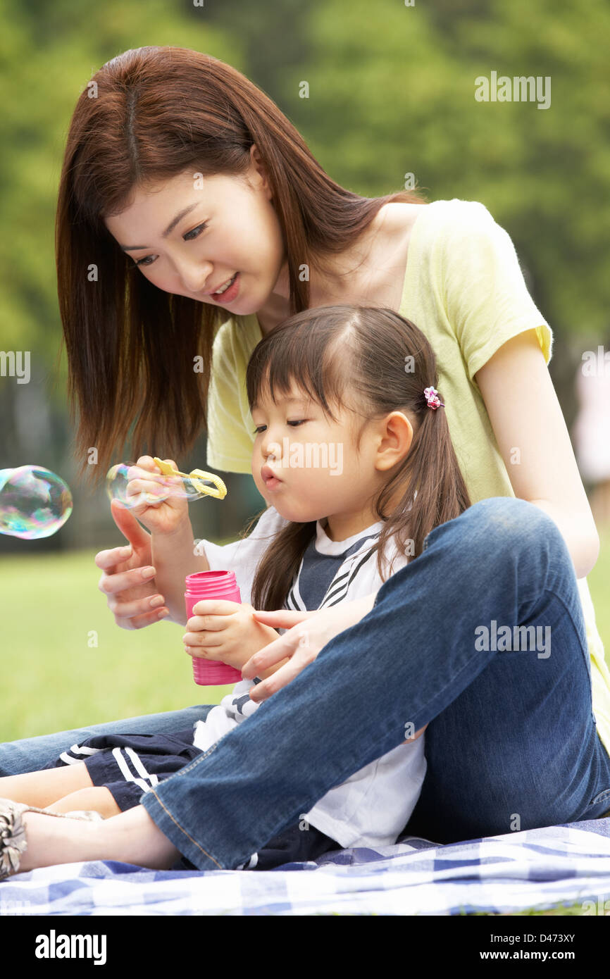 Chinesisch-Mutter mit Tochter im Park Seifenblasen Stockfoto