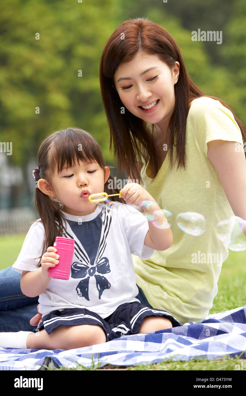 Chinesisch-Mutter mit Tochter im Park Seifenblasen Stockfoto