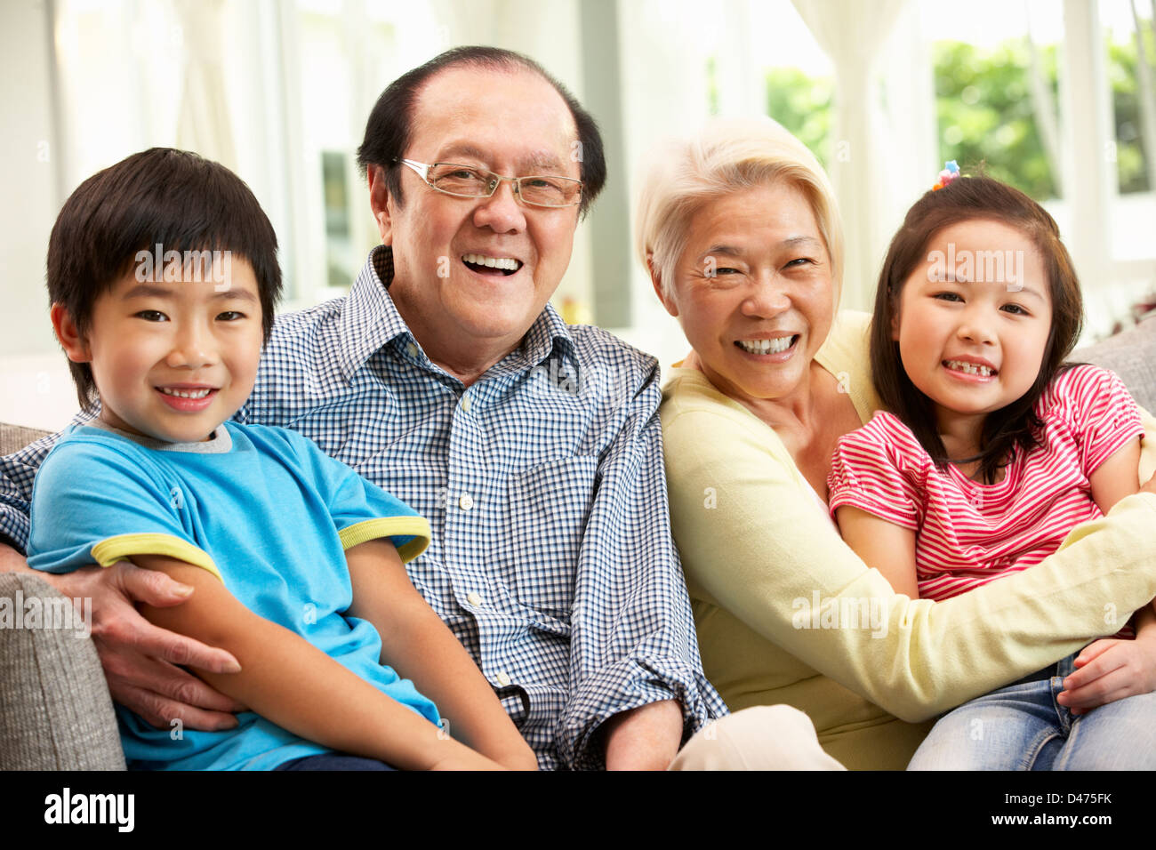 Porträt des chinesischen Großeltern mit Enkeln entspannendes Zuhause zusammen Stockfoto