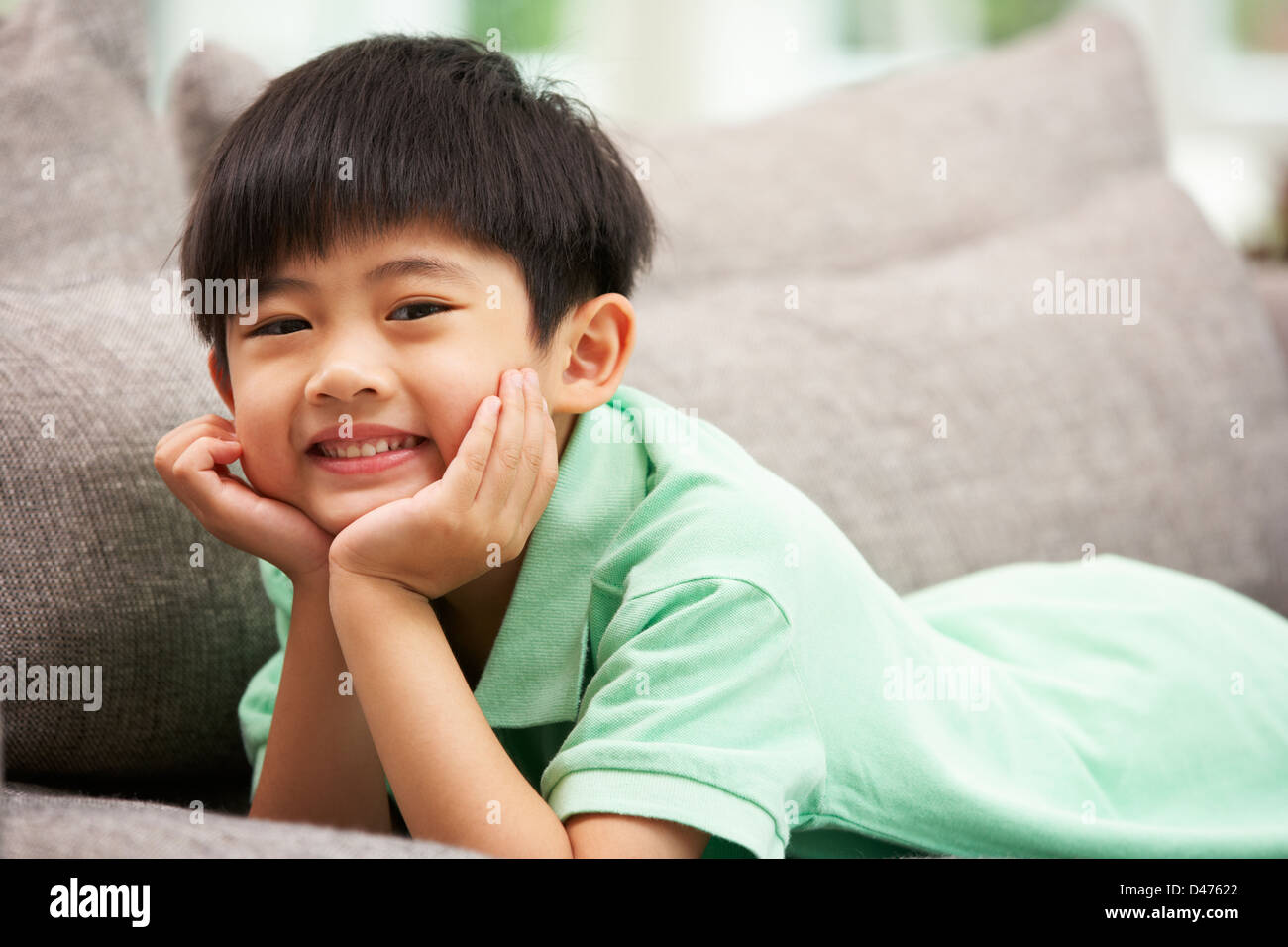 Junge chinesische Entspannung zu Hause auf Sofa Stockfoto
