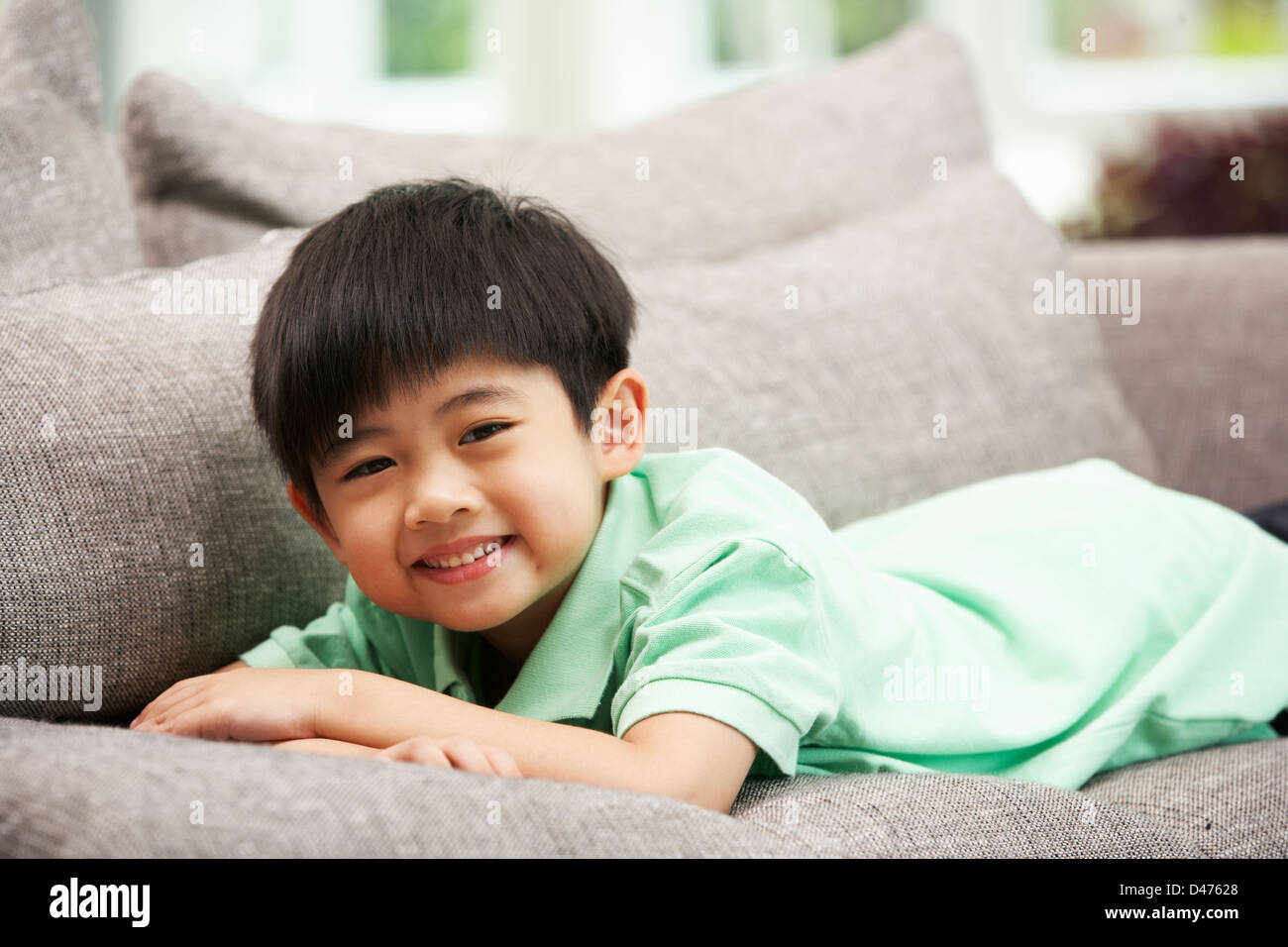 Junge chinesische Entspannung zu Hause auf Sofa Stockfoto