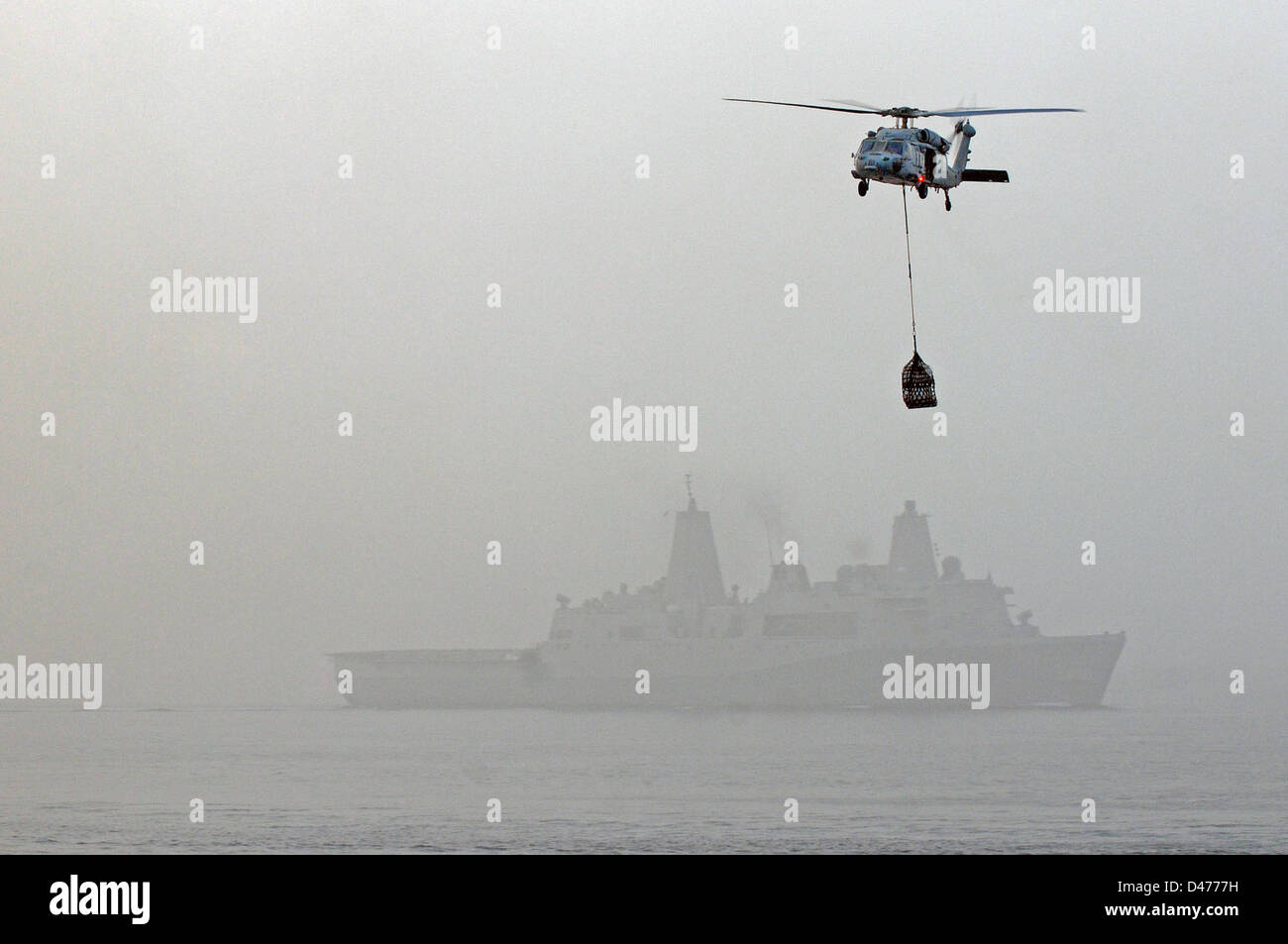 Ein MH-60 s Sea Hawk-Hubschrauber trägt Lieferungen während im Gange Nachschub Evolution Stockfoto
