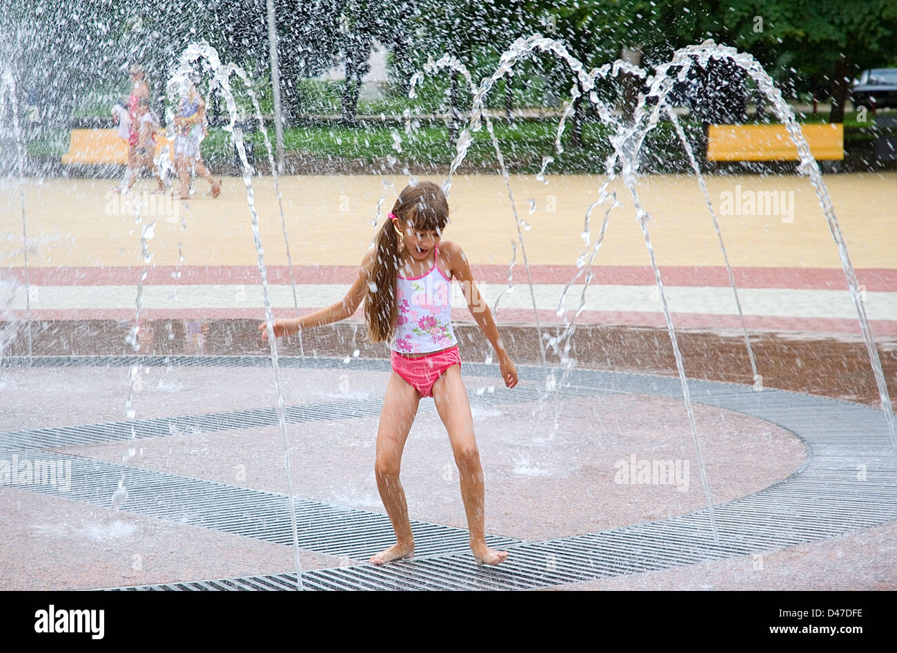 Das Mädchen badet in einem Brunnen in heißen Tag Stockfoto