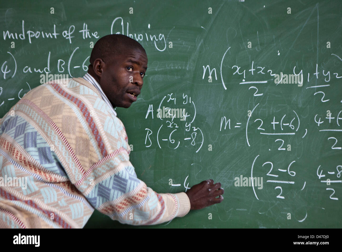 Südafrikanischen Lehrer befasst sich mit seiner Klasse, schreibt er eine Mathe-Formel auf dem schwarzen Brett. Cape Town, Südafrika. Stockfoto
