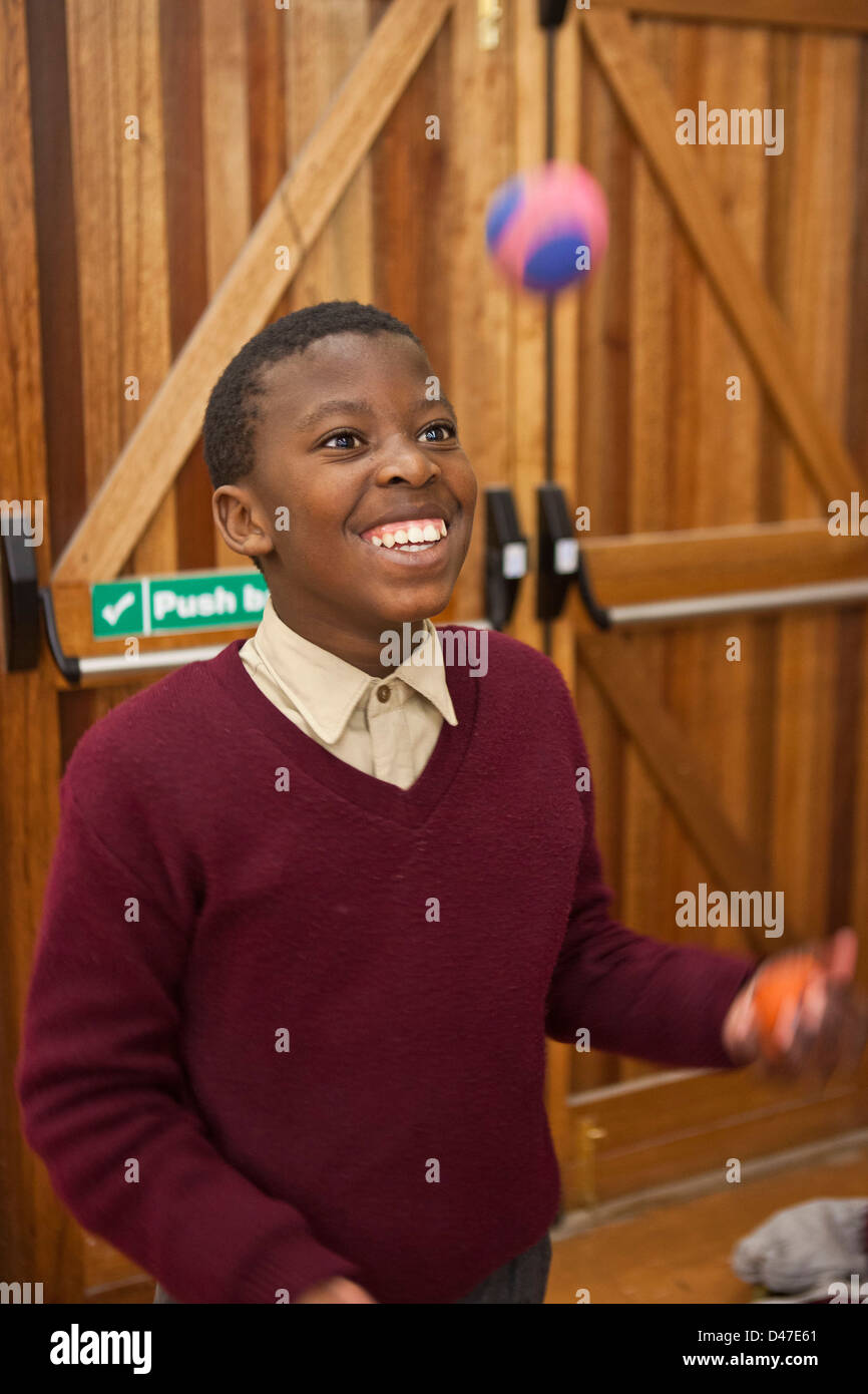 Afrikanische Schuljunge Jonglierbälle als Teil einer Zirkus-Klasse im Saal der Siyazakha Primary School, Township Philippi, Kapstadt. Stockfoto