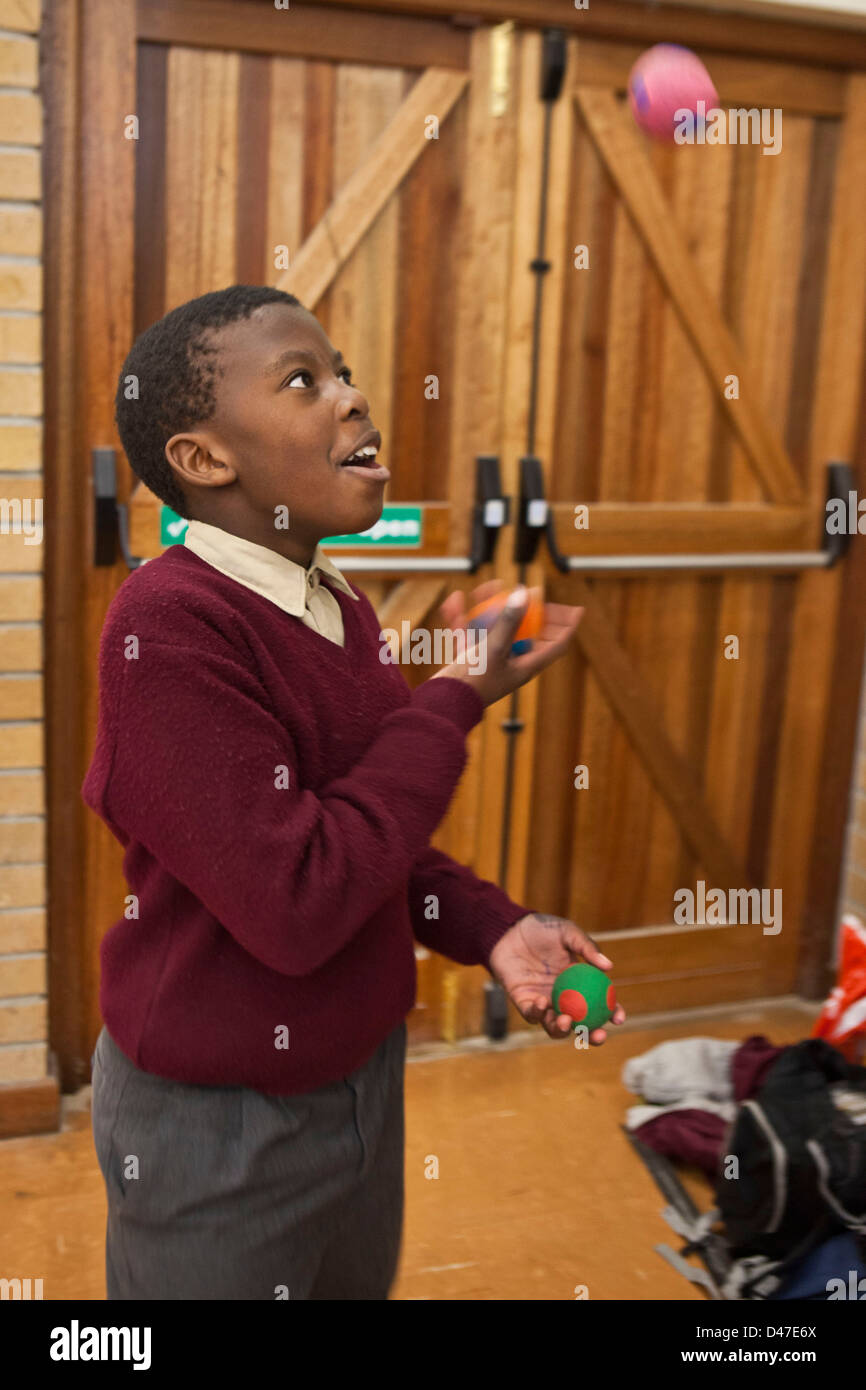 Afrikanische Schuljunge Jonglierbälle als Teil einer Zirkus-Klasse im Saal der Siyazakha Primary School, Township Philippi, Kapstadt. Stockfoto