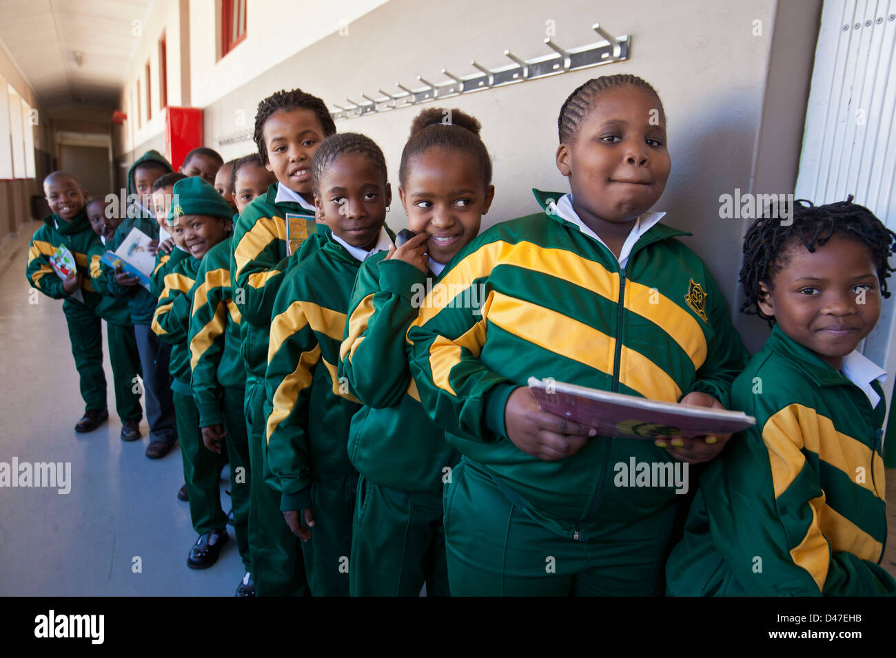Schülerinnen und Schüler Schlange stehen, um in ihrer Lesung gehen / Alphabetisierung Klasse, Cape Town, Südafrika. Stockfoto