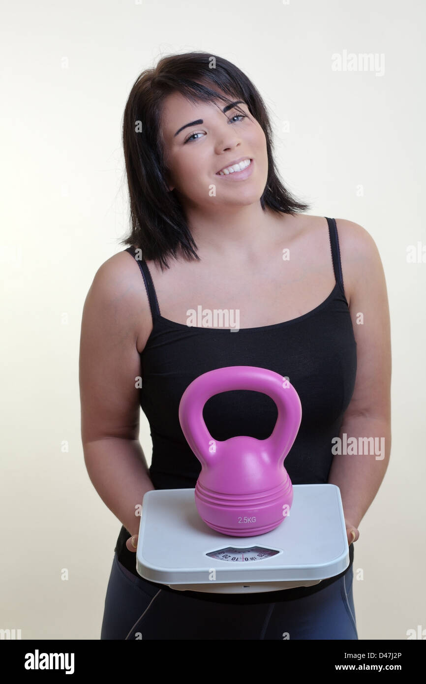 Konzept-Bild Modell Holding Skalen mit einer Kettlebell zeigt Ihnen, wie Shes gonna Verlust Gewicht und fit Stockfoto