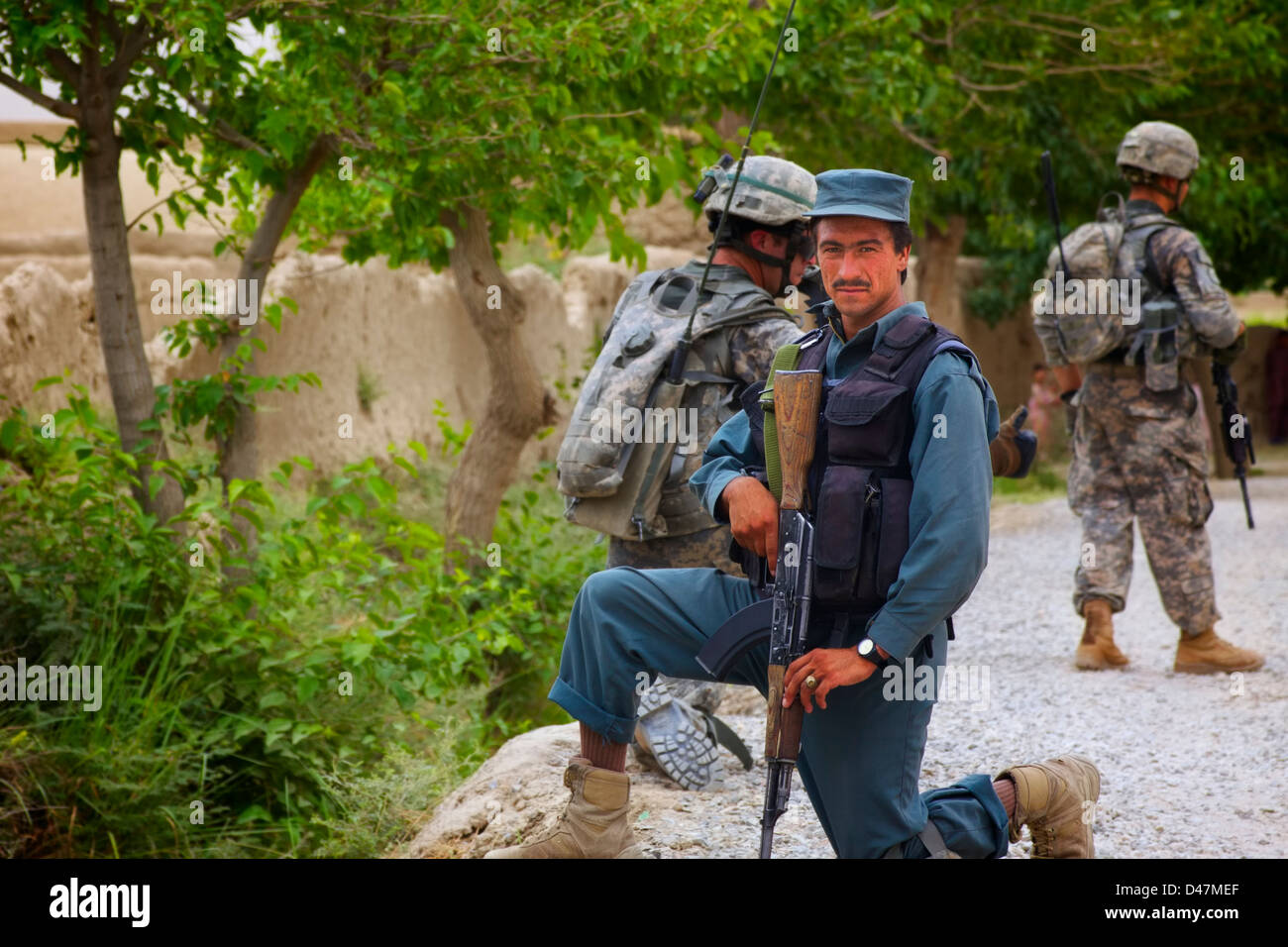 Kandahar, Afghanistan - 24. September 2010: Ein afghanischer nationaler Polizist nimmt eine Knie auf einer gemeinsamen U.S.-ANP-Patrouille. Stockfoto
