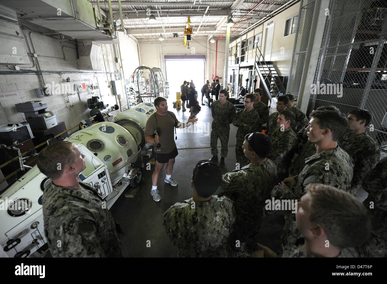 Ein Navy-Taucher demonstriert den Midshipmen der U.S. Naval Academy die Verwendung einer transportierbaren Rekompressionskammer und zeigt die Bedeutung der Kammer für Tauchoperationen während eines Besuchs in der Gegend von Hampton Roads. Stockfoto