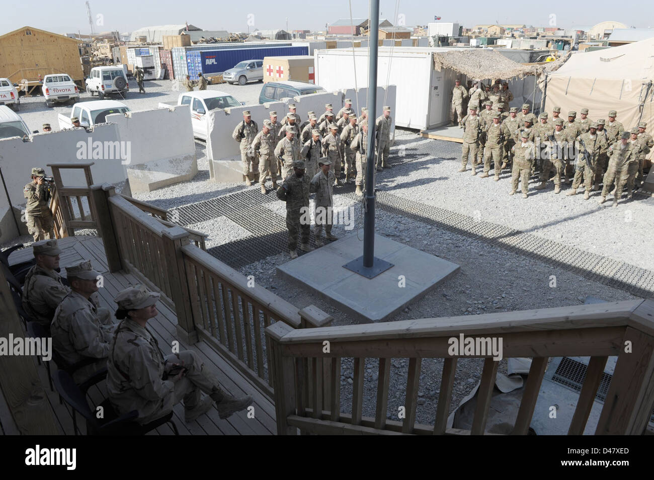 Seabees versammeln sich um eine Fahnenstange in einer Camp-Umsatz-Zeremonie am Kandahar Flugplatz. Stockfoto