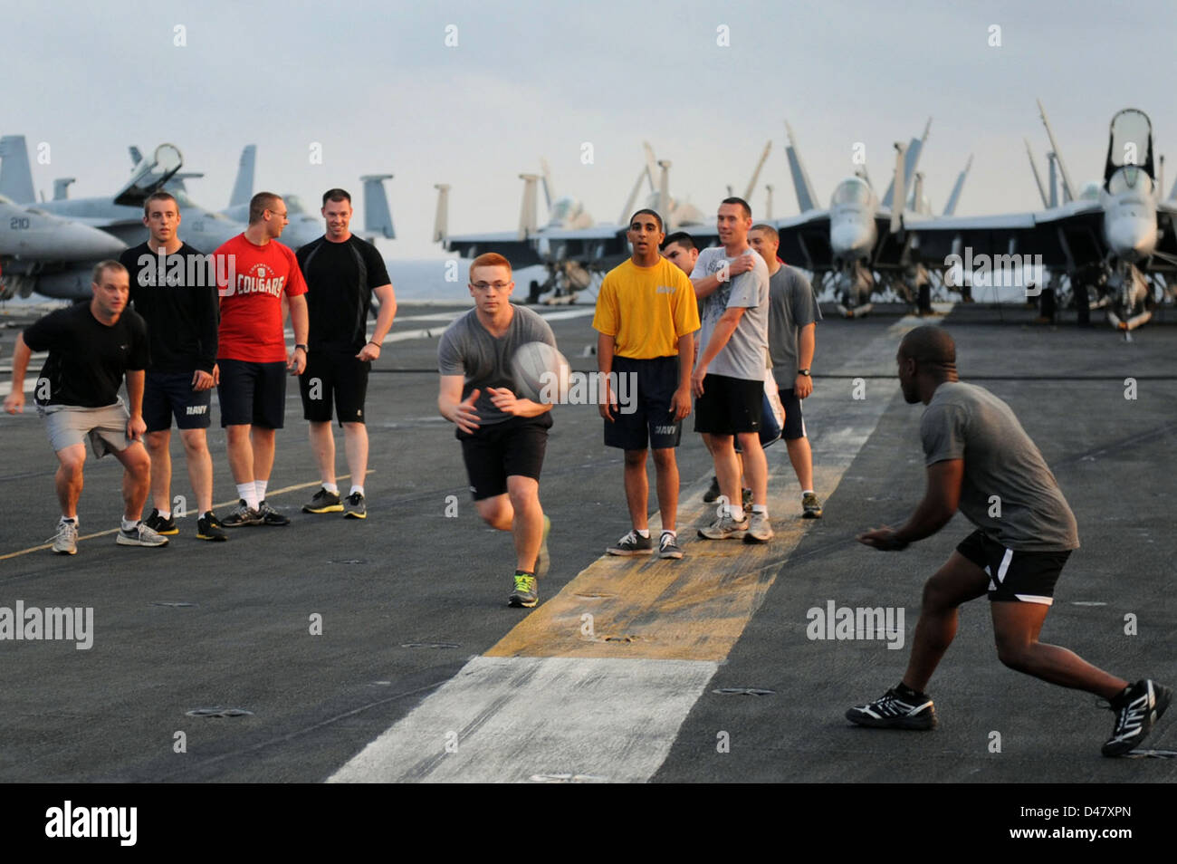 Das Rugby-Team an Bord der USS Dwight D. Eisenhower trainiert auf dem Flugdeck und kombiniert militärische Fitness mit Teamarbeit als Teil ihrer körperlichen Einsatzbereitschaft im Atlantik. Stockfoto