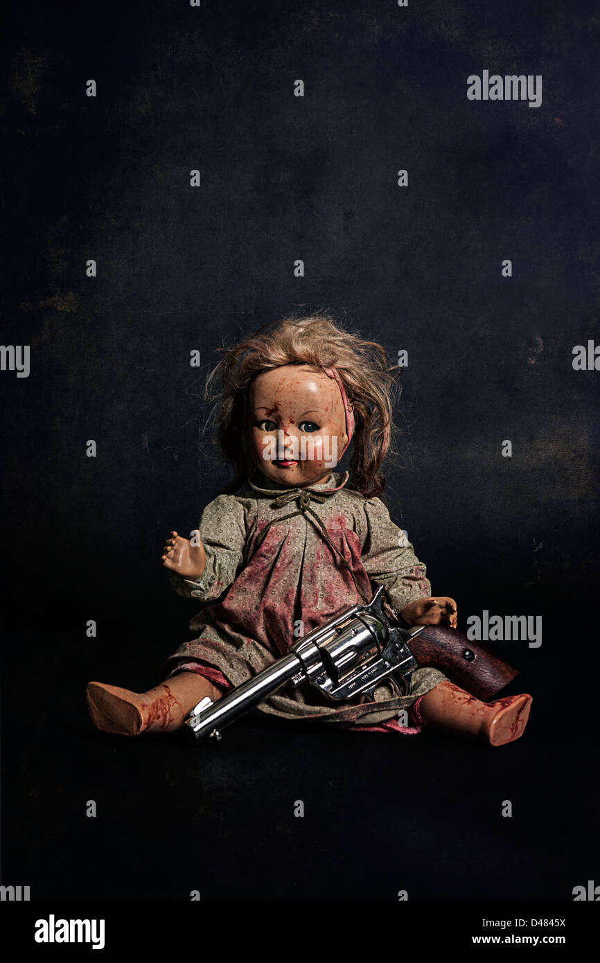 eine gruselige Puppe mit einer Pistole Stockfoto