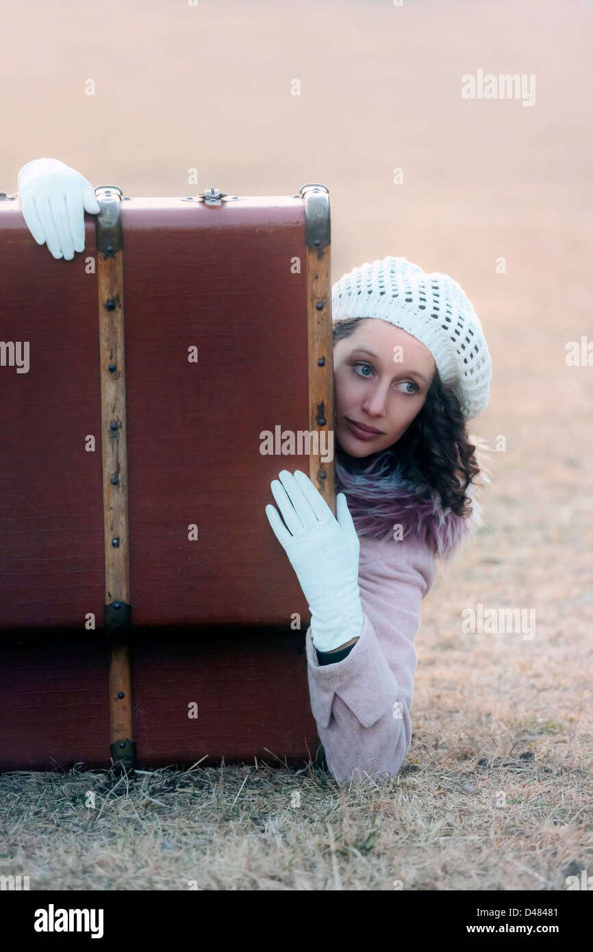 eine Frau liegt in einem alten Koffer Stockfoto