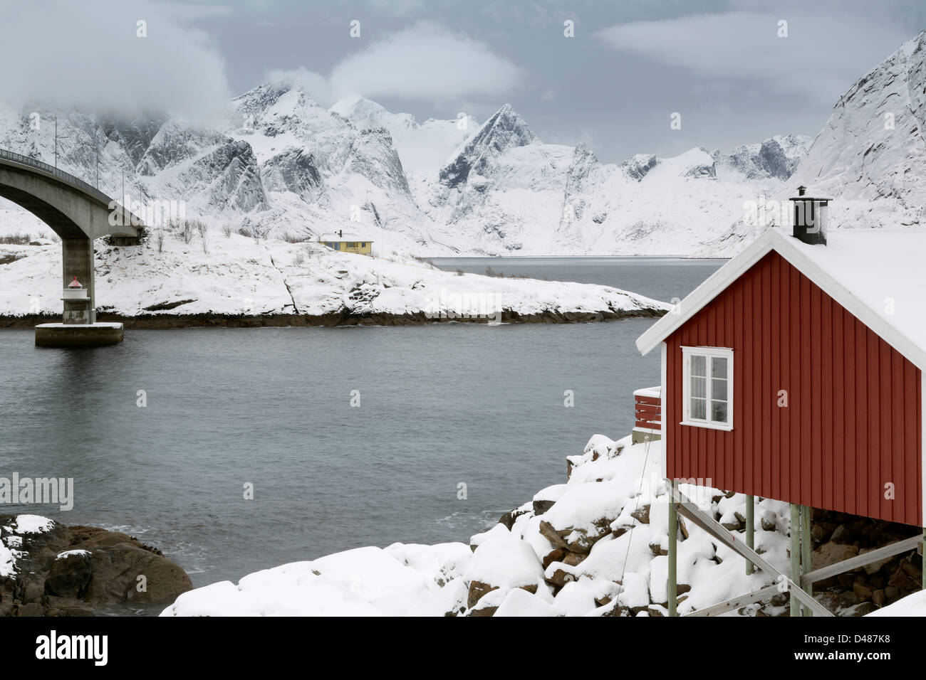 Eine traditionelle Fischerhütte (Rorbu) Hamnoya Fischerdorf zu einer Straßenbrücke über Reinefjord auf den Lofoten-Inseln, Stockfoto