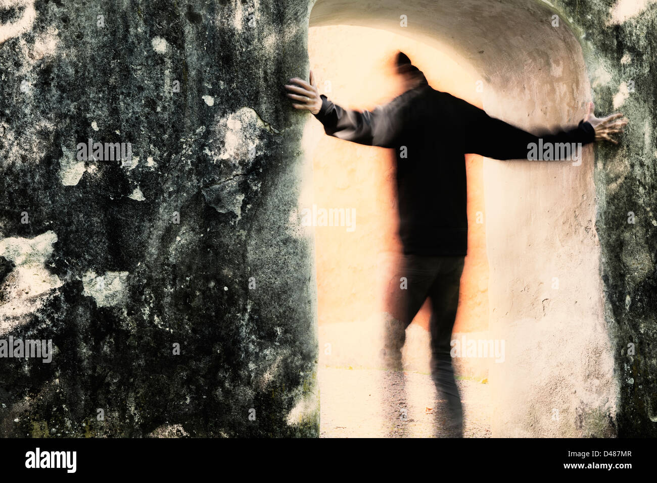 Männchen aus der Dunkelheit ins Licht durch Portal bewegen. Er hält an der Steinmauer. Stockfoto