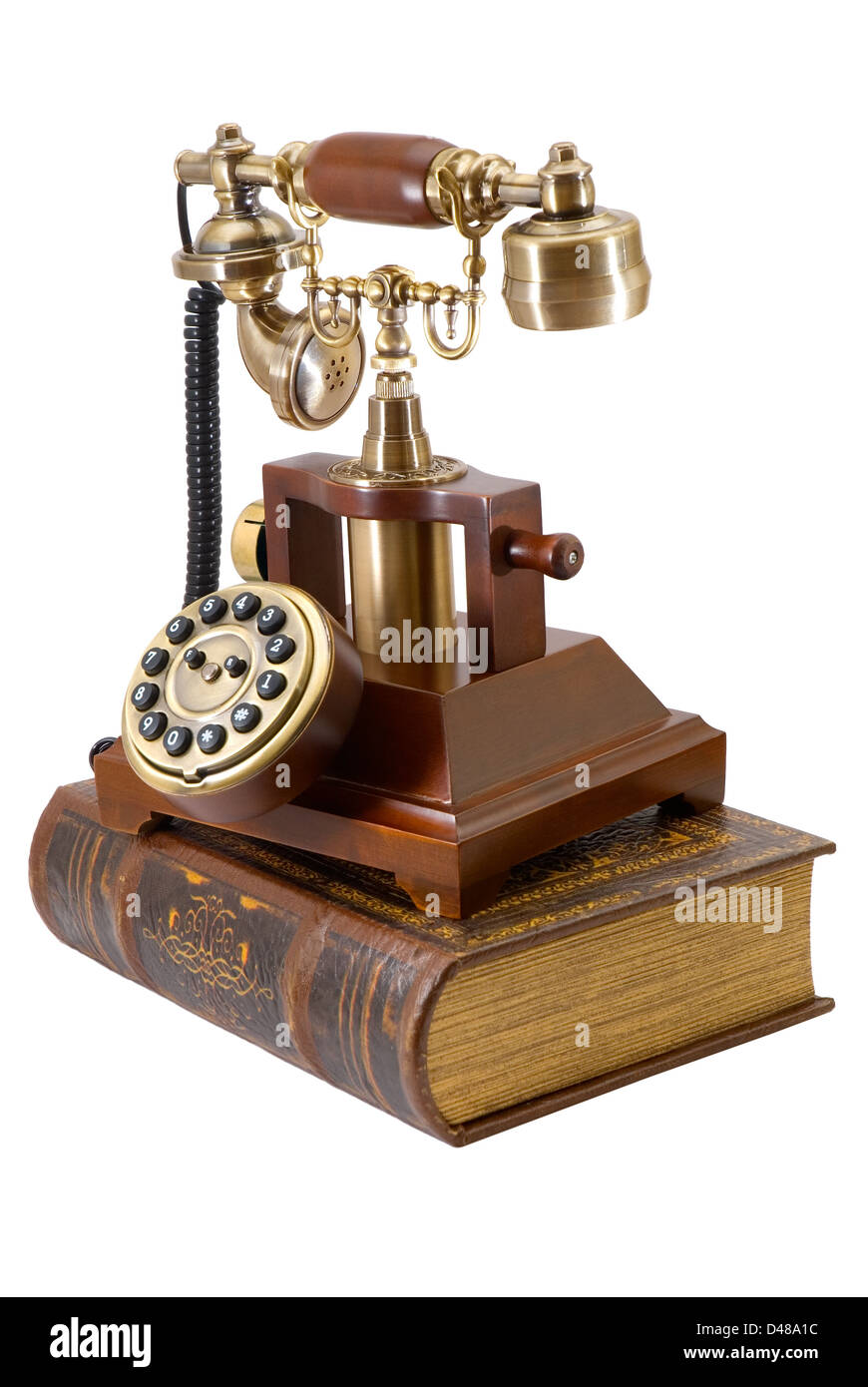 Alte Telefon und Buch werden auf weißem Hintergrund fotografiert. Stockfoto