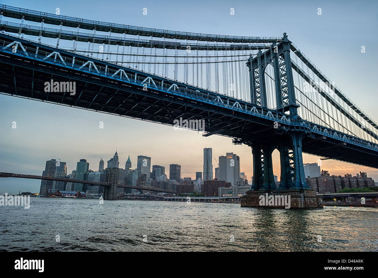 Manhattan Bridge, Brooklyn Bridge & lower Manhattan vom East River bei Sonnenuntergang. New York City, New York Stockfoto