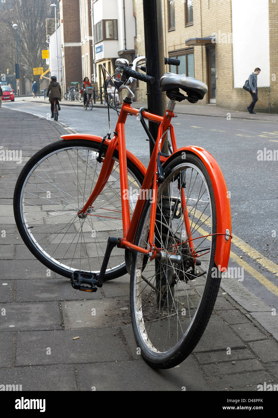 Orange Fahrrad in Round Church Street Cambridge England Stockfoto