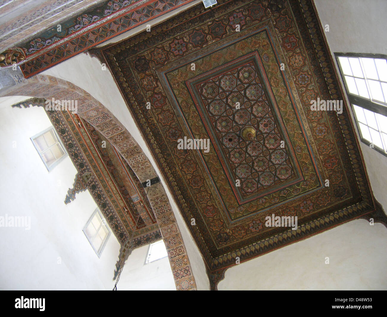 Die Decke im Bayt al-'Aqqad in Damaskus, Syrien, ist ein Paradebeispiel islamischer Architektur. Das komplizierte Design spiegelt traditionelle Handwerkskunst wider, mit detaillierten Mustern und geometrischen Formen. Das Gebäude aus Jahrhunderten zeigt eine Mischung aus kulturellen Einflüssen, darunter arabische und osmanische Elemente. Diese Decke trägt zur historischen Bedeutung des Raumes bei und diente während der Osterzeit 2004 als Empfangsraum. Stockfoto Die Decke im Bayt al-'Aqqad in Damaskus, Syrien, ist ein Paradebeispiel islamischer Architektur. Das komplizierte Design spiegelt traditionelle Handwerkskunst wider, mit detaillierten Mustern und geometrischen Formen. Das Gebäude aus Jahrhunderten zeigt eine Mischung aus kulturellen Einflüssen, darunter arabische und osmanische Elemente. Diese Decke trägt zur historischen Bedeutung des Raumes bei und diente während der Osterzeit 2004 als Empfangsraum. Stockfoto