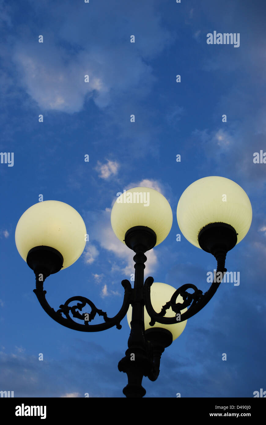 Straßenlaterne in der Abenddämmerung auf blau bewölktem Himmelshintergrund Stockfoto