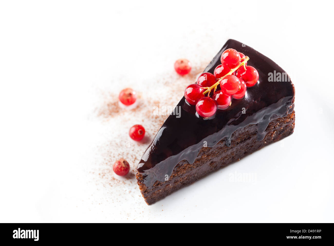 Stück Schokoladenkuchen mit roten Beeren auf weißem Hintergrund Stockfoto