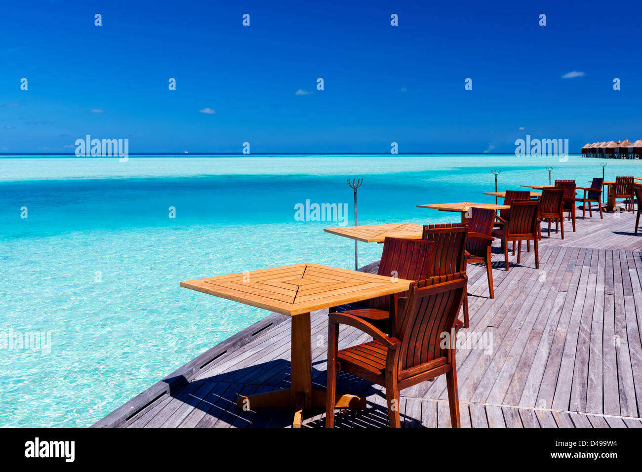 Leere Tische und Stühle im tropischen Strandrestaurant Stockfoto