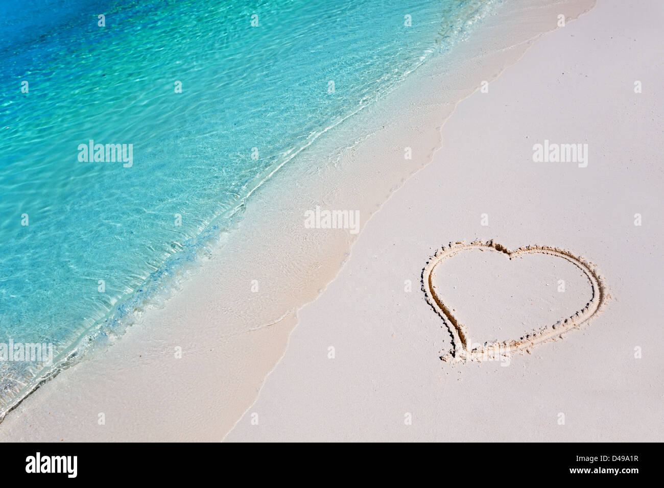 Herz am weißen Sandstrand im tropischen Paradies Stockfoto