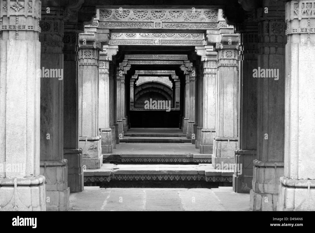 Säulen mit Schnitzwerk an den berühmten Adalaj Vav Stufenbrunnen Denkmal in Ahmedabad, Indien Stockfoto