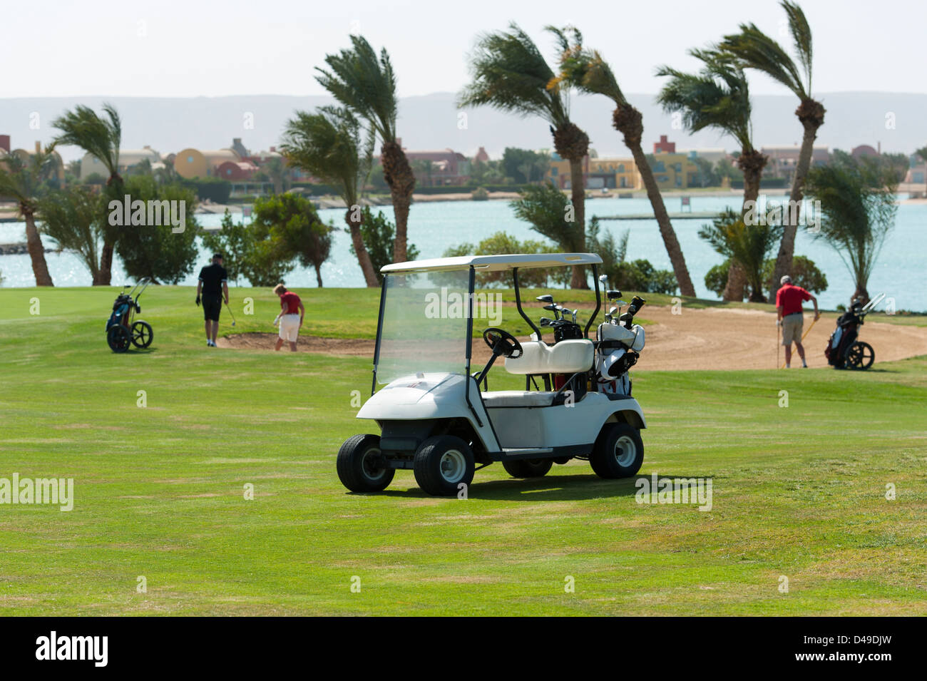 Elektro-Golf-Buggy auf dem Fairway mit Golfern in der Ferne Stockfoto