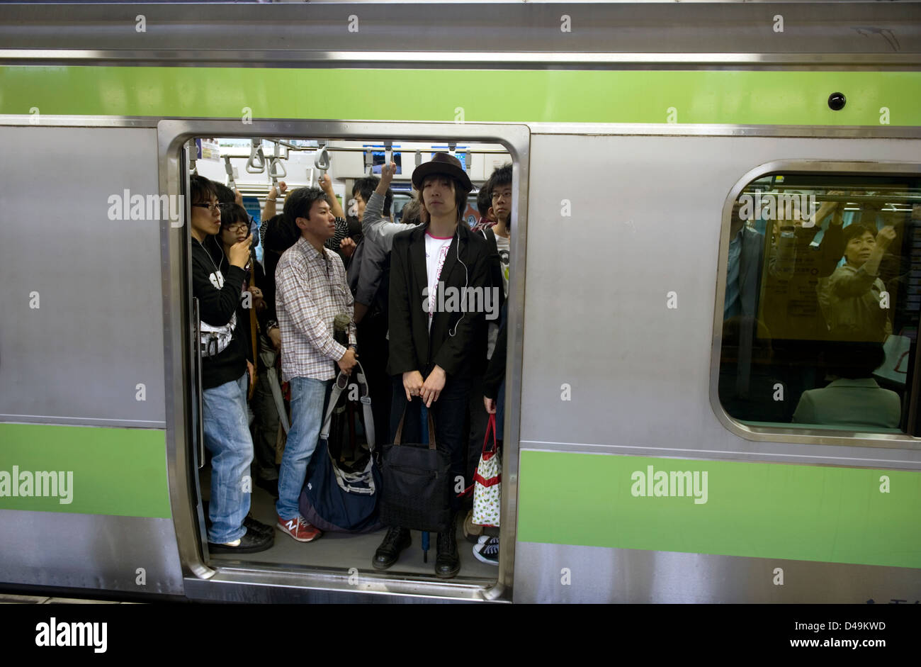 Pendler stehen an Bord der Yamanote-Schleife Zuglinie, die Kreise um die Stadt Tokio, Japan. Stockfoto