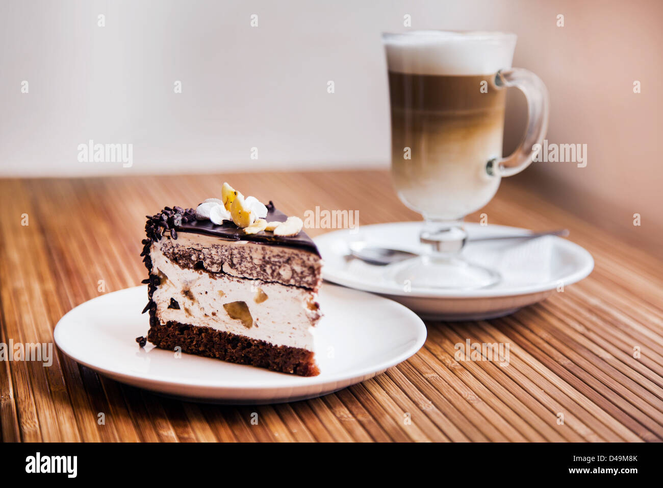 Ein Stück Schokoladenkuchen auf einen Teller, Kaffee im Hintergrund Stockfoto