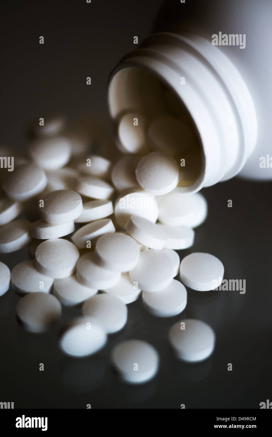 Aspirin-Tabletten fallen aus dem Glas Stockfoto