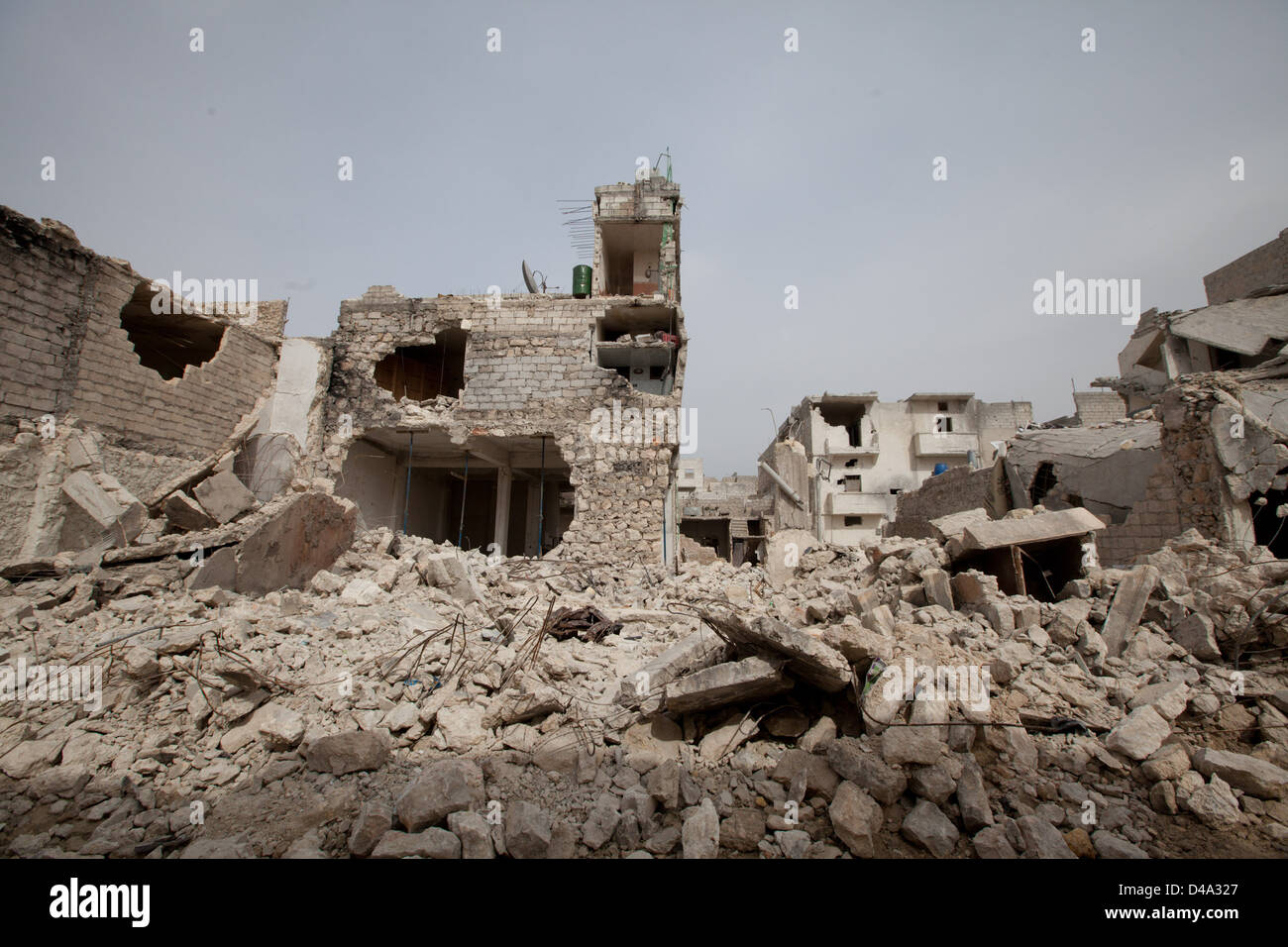 Die Menschen gehen durch beschädigte Gebäude nach eine Oberfläche zu Oberfläche Rakete Tariq Al-Bab-Abschnitt von Aleppo getroffen. Stockfoto