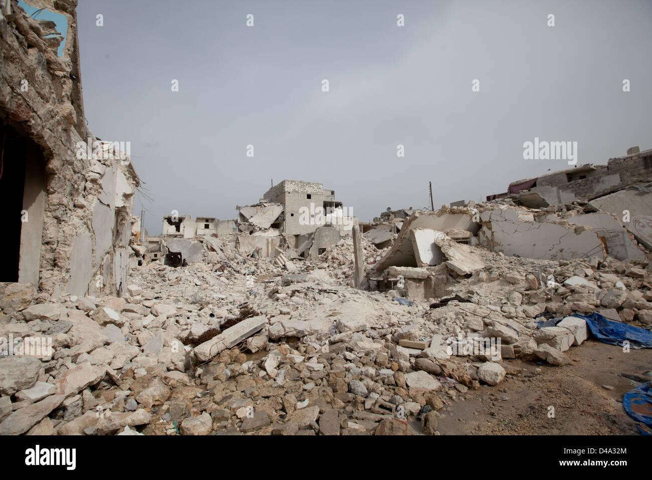 Die Menschen gehen durch beschädigte Gebäude nach eine Oberfläche zu Oberfläche Rakete Tariq Al-Bab-Abschnitt von Aleppo getroffen. Stockfoto