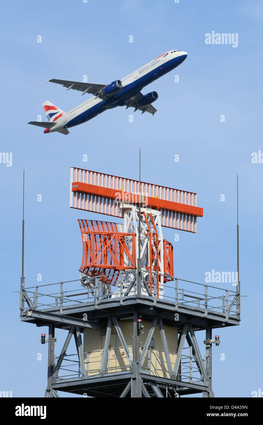 Die Radarantenne der Air Traffic Control am Flughafen London Heathrow lhr UK wird von einem Flugzeug der British Airways Boeing 777 überflogen Stockfoto