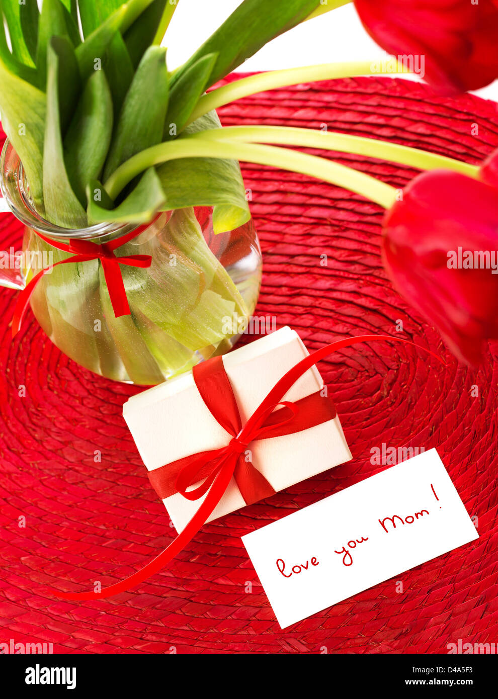Bild der schönen romantischen Stilleben für Muttertag, frische rote Tulpe Blumen in Glasvase, niedlichen kleinen weißen Geschenkbox Stockfoto