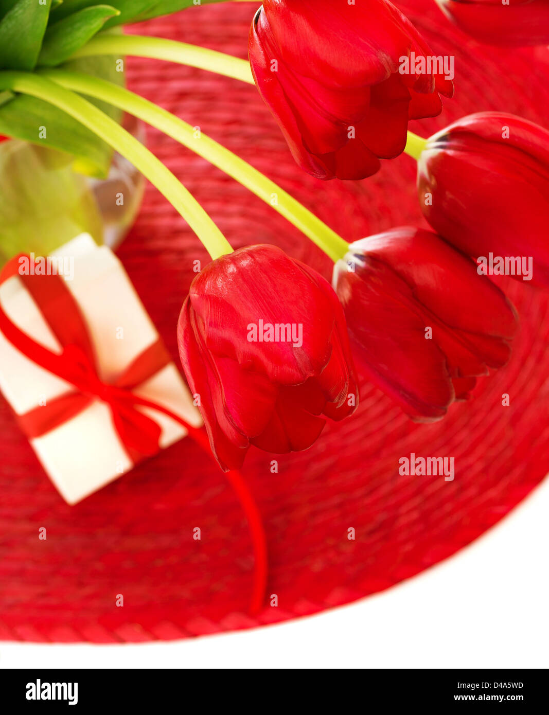Bild von schöne rote Tulpe Blumen in Glasvase mit kleinen weißen Geschenkbox auf dem Tisch, romantische Stillleben, Stockfoto