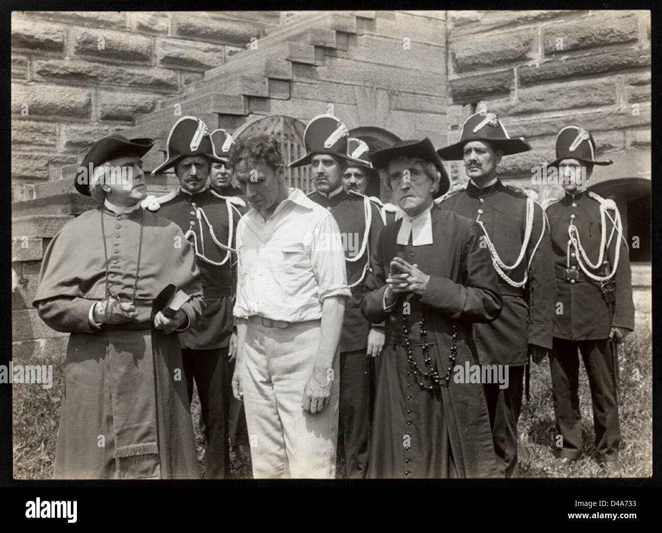 Dieser Stummfilm *The Country Parson* aus dem Jahr 1915 zeigt einen Mann, der als Pfarrer verkleidet ist und in einer Außenumgebung mit einer Treppe gedreht wurde. Der Schwarzweiß-Film zeigt typische Kostüme der Zeit und spiegelt Kinostile des frühen 20. Jahrhunderts wider. Stockfoto