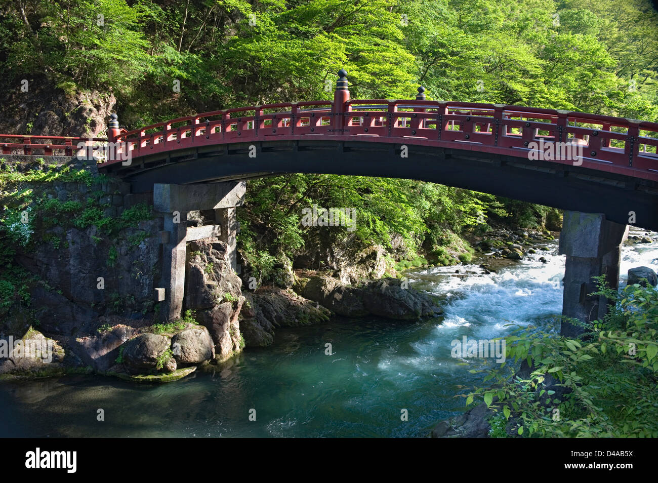 Die Futarasan Schrein Shinkyo Heilige Brücke über ein klares Wasserstrom in Nikko, Tochigi, Japan. Stockfoto