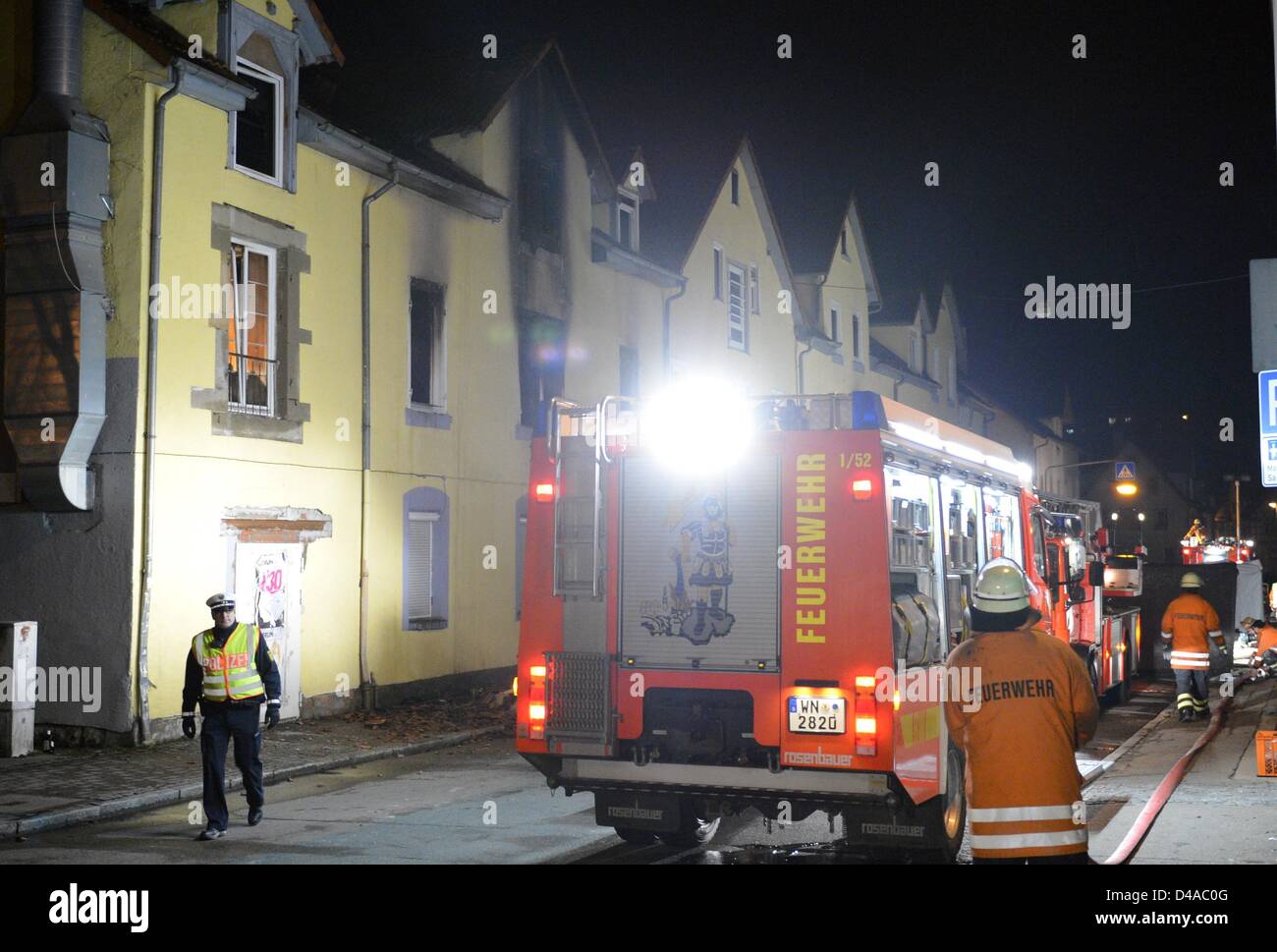 Feuerwehrleute sichern das Gebiet um ein Haus, in dem eine Frau und sieben Kindern in einem Feuer am frühen Morgen in Backnang, Deutschland, 10. März 2013 starb. Foto: Bernd Weissbrod Stockfoto