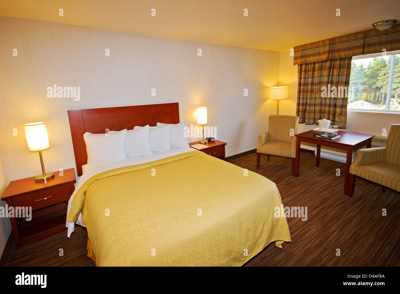 Master-Schlafzimmer mit Queensize-Bett, Holzboden und weiße Decke. Stockfoto