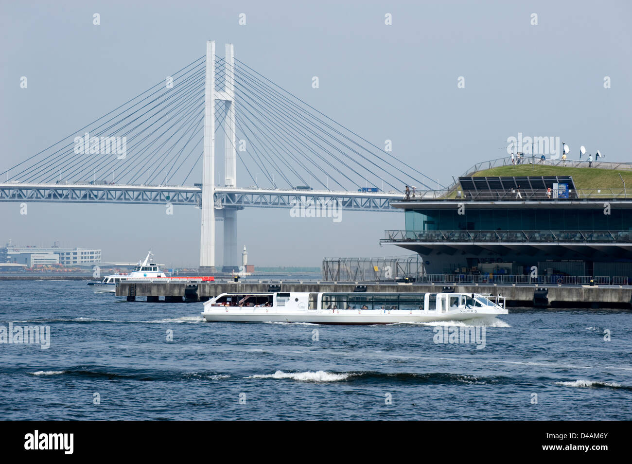 Eine Kreuzfahrt-Schiff Reißverschlüsse an den International Passenger Terminal und Yokohama Bay Bridge an der belebten Uferpromenade von Yokohama, Japan. Stockfoto