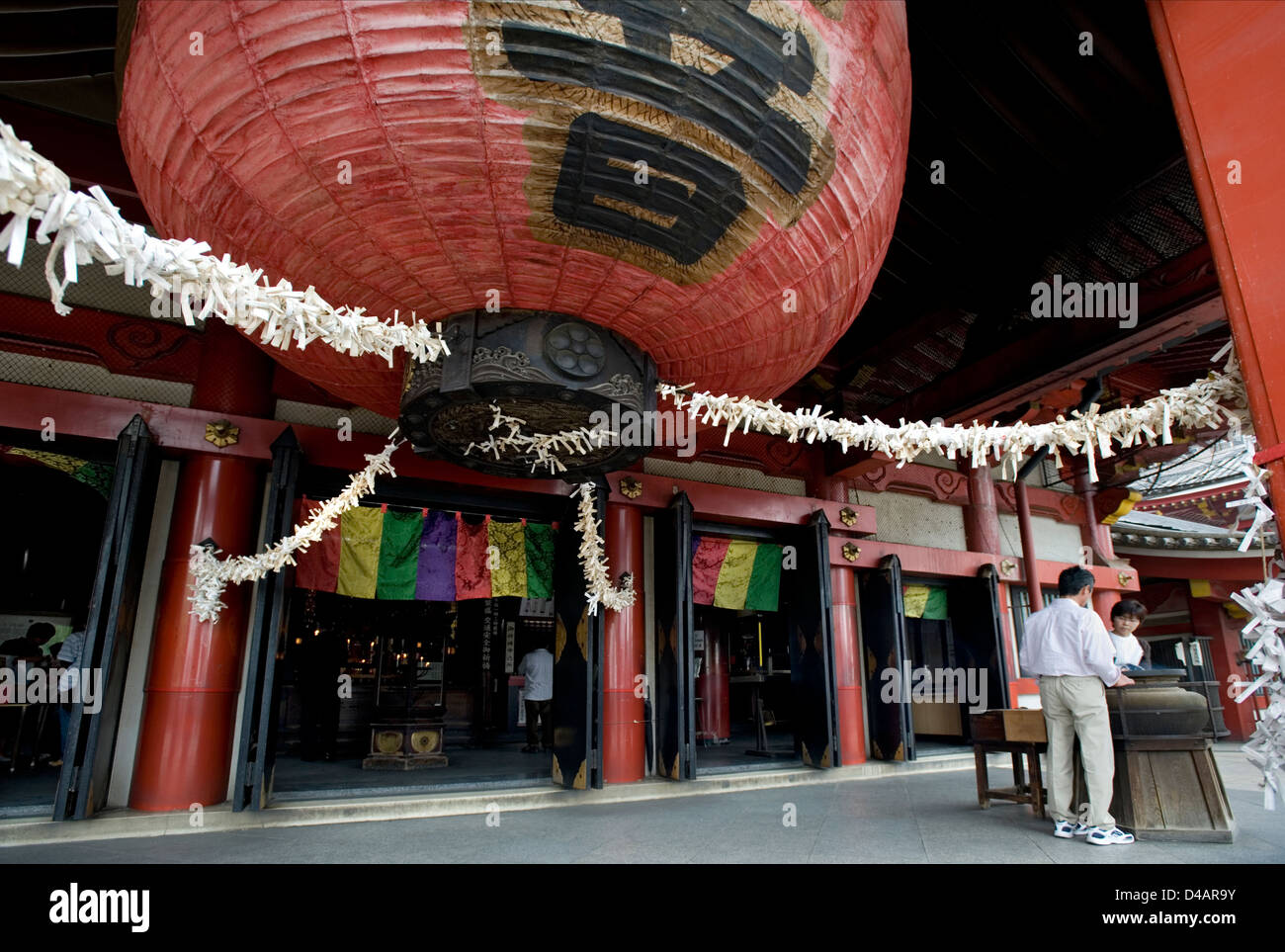 Riesige rote Chochin Papierlaterne mit Omikuji (Oracle) Papier Vermögen gebunden an Seilen hängt am Eingang zu Osu Kannon Tempel Stockfoto