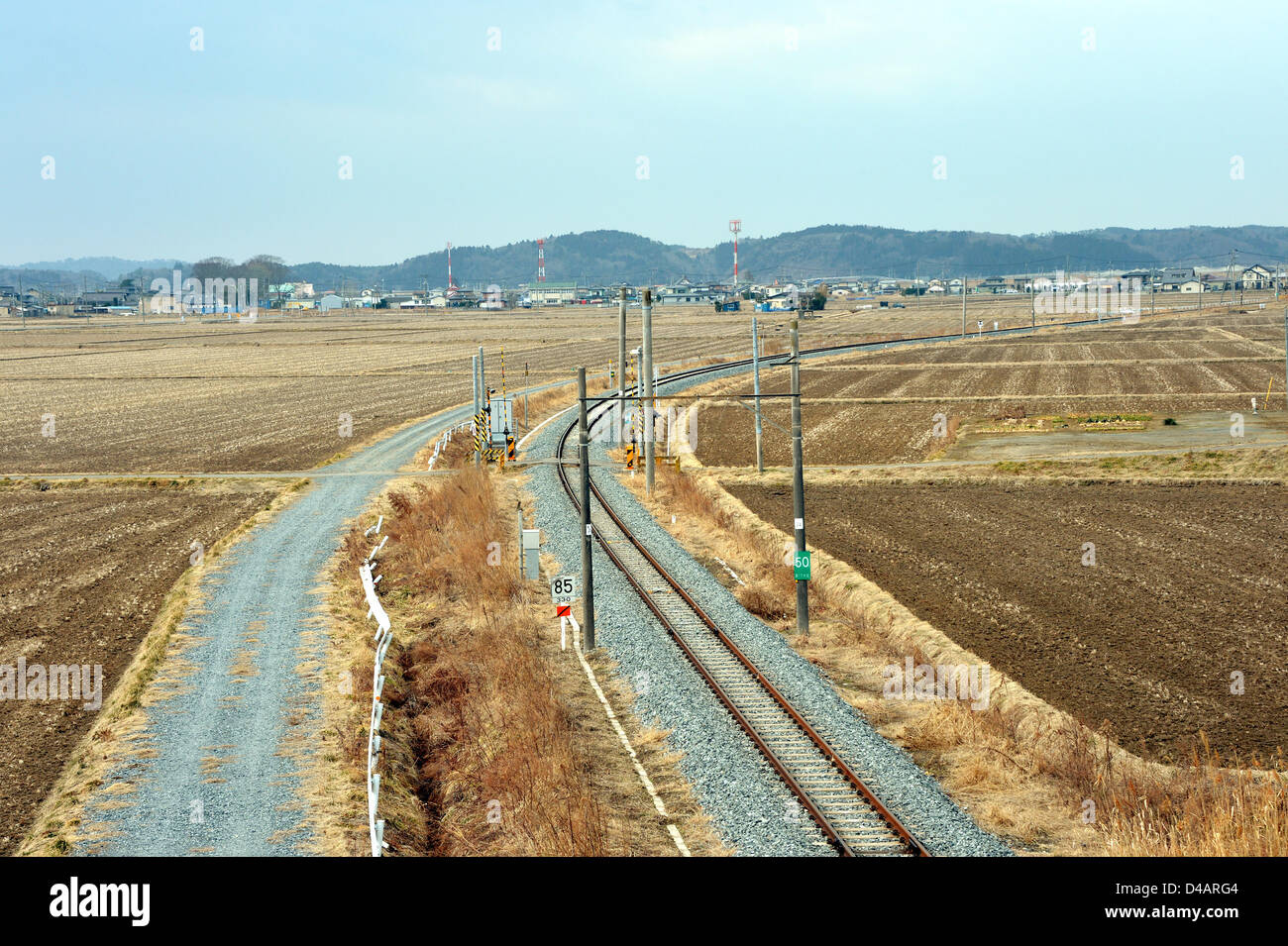 8. März 2013, Higashi-Matsushima, Japan - durchschneidet eine eingleisige Bahnstrecke der lokalen Eisenbahn kultivierten Feldern in der Nähe von Higashi-Matsushima, Präfektur Miyagi, am 8. März 2013. Die Senseki-Linie, die Sendai, Präfektur Hauptstadt mit Hafen-Stadt Ishinomaki an der Pazifikküste verbindet wurde vor zwei Jahren am 11. März als Magnitude 9,0 Erdbeben und anschließenden Tsunami schlug der Nation Nordosten verlassen mehr als 15.000 Menschen Tote und außergewöhnlichen breitere Schwaden der Küstenstädte und Dörfer durchtrennt.  (Foto von Natsuki Sakai/AFLO) Stockfoto