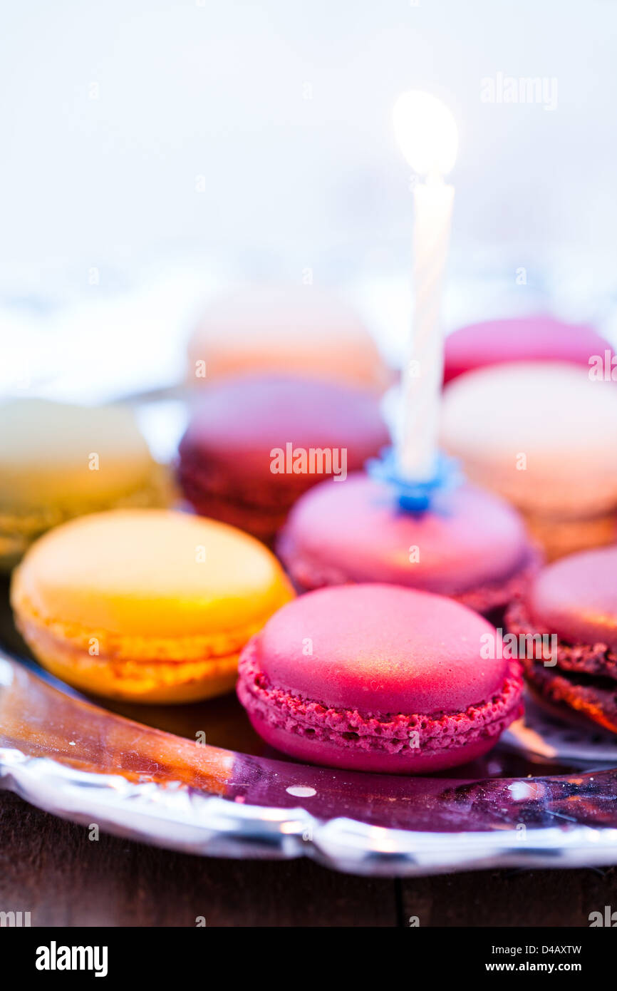 Nahaufnahme von Makronen mit Kerze auf dekorativen silbernen Tablett Stockfoto